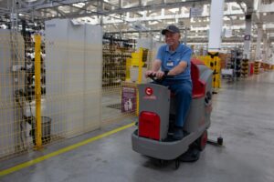 Професійний спеціаліст компанії The Cleaning Pro Group (CPG) у фірмовій захисній екіпіровці очищує складні забруднення та промисловий пил з елементів виробничого обладнання.